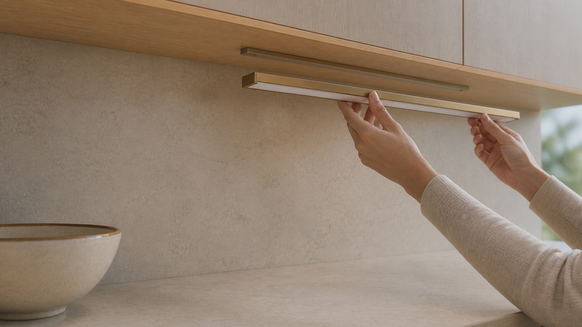 Aurelia rechargeable task light being mounted beneath a kitchen cabinet and switched on